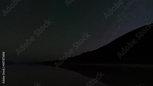Timelapse night to day transition of north star reflected in ancient Lake Manly at Badwater Basin in Death Valley National Park in California, USA photo