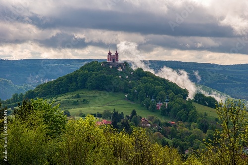 Summer morning at sunrise with fog and historic chapel on the hill, hiking in the mountains.. Calvary over clouds in Banska Stiavnica, Slovakia. Summer landscape after a storm