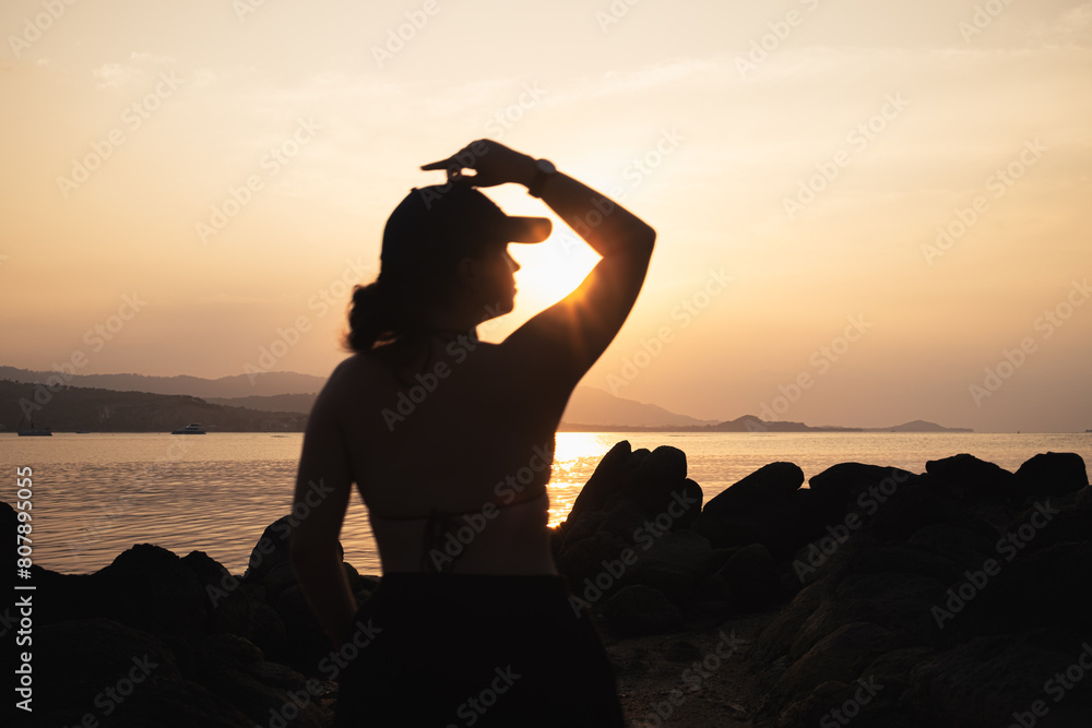 silhouette of a person on a rock, Sundays sunstar shining trough their arm bend on Thailand Koh Samui