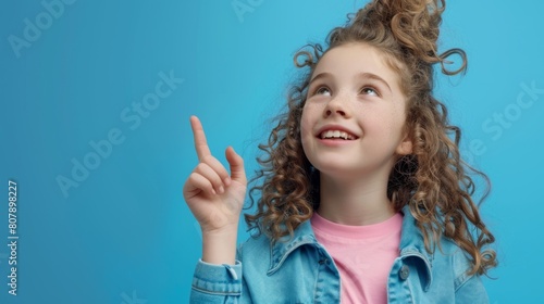 Girl Pointing Upwards with Excitement photo