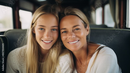 Smiled, happy blond mother and her daugther travelling together in a bus © MonkaLemonka