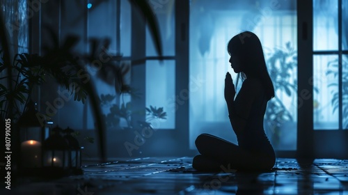 A woman is praying in a dark room. photo