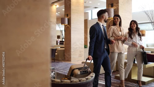 Young businessman and his female colleague arriving at the hotel on a business conference photo