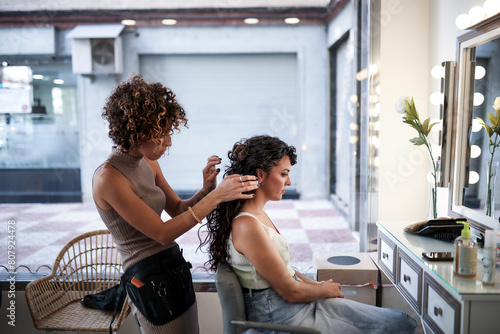 Professional stylist working with curly hair client