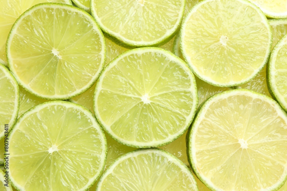 Fresh juicy lime slices as background, top view Fresh juicy lime slices as background, top view