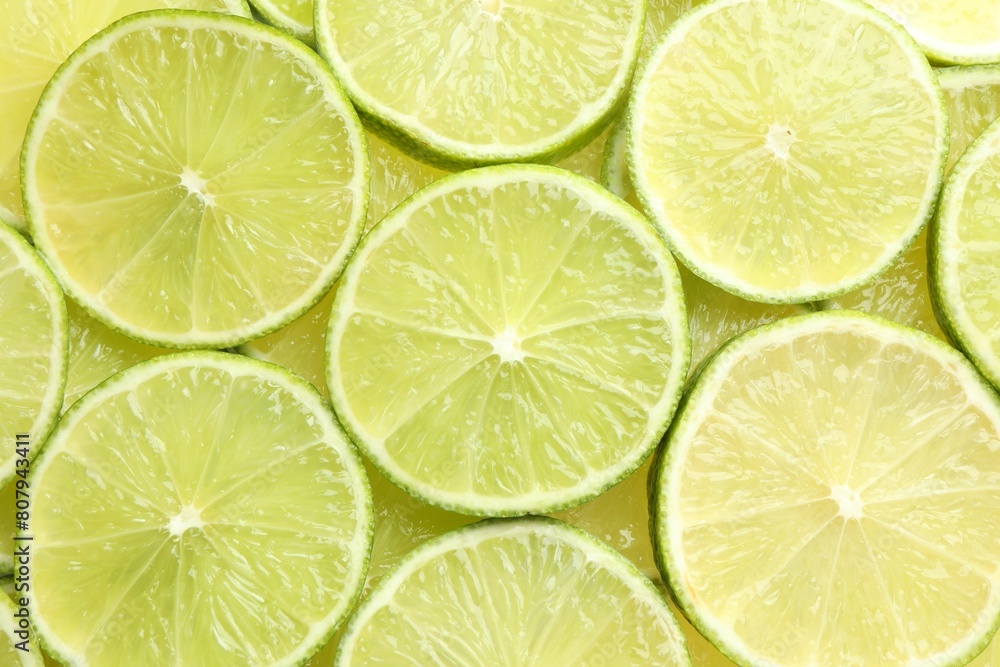 Fresh juicy lime slices as background, top view