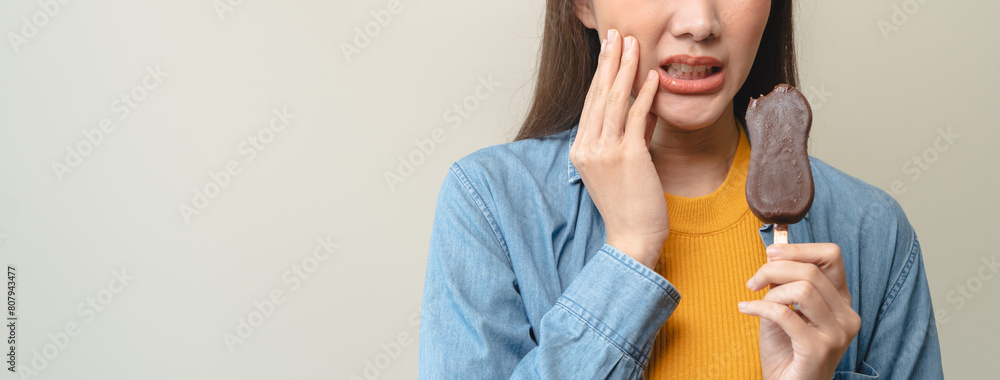 Face expression suffering from sensitive teeth, Asian young woman touching cheek Face expression suffering from sensitive teeth, Asian young woman touching cheek