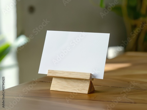horizontal postal card in wooden stand, on top of a table