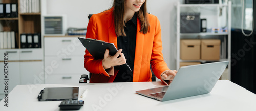business documents on office table with smart phone and digital tablet and graph financial and woman working