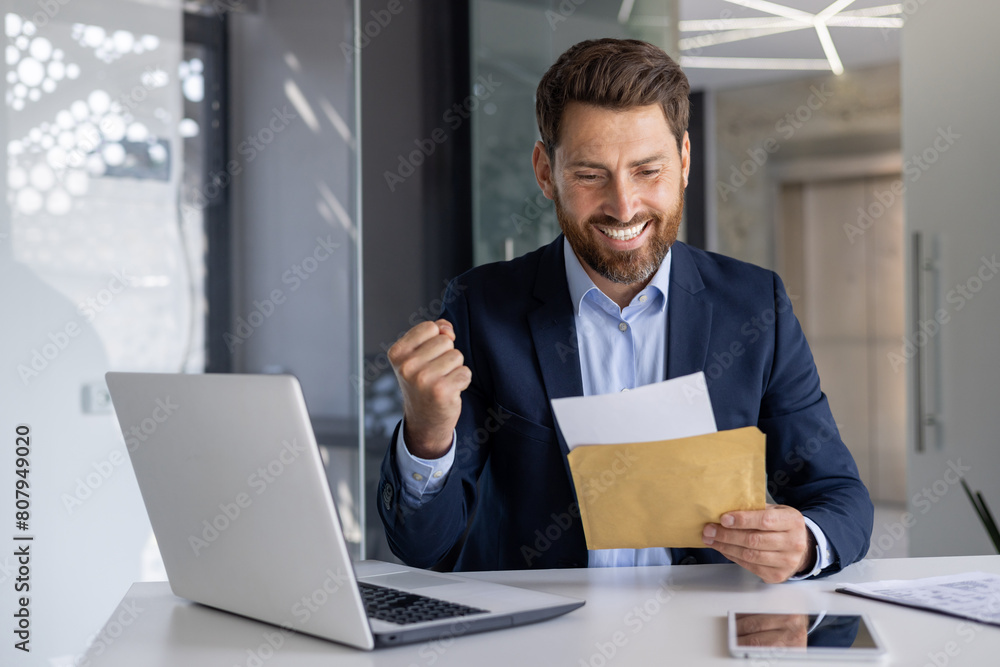 Successful businessman celebrates with joy at office desk Successful businessman celebrates with joy at office desk