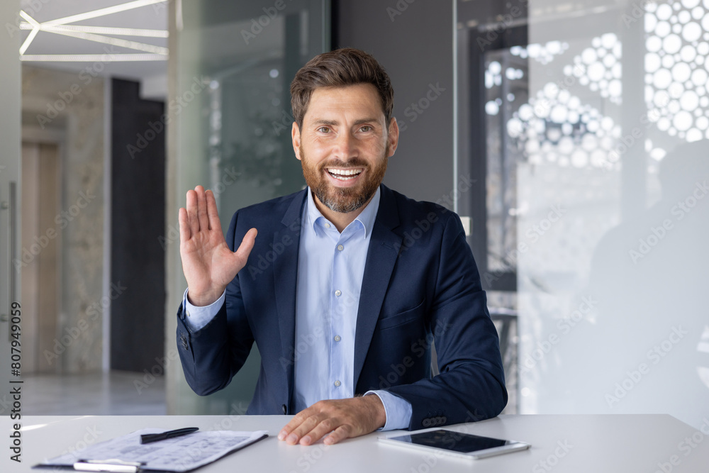 Fototapeta premium Friendly Businessman Waving Hand in Modern Office Setting