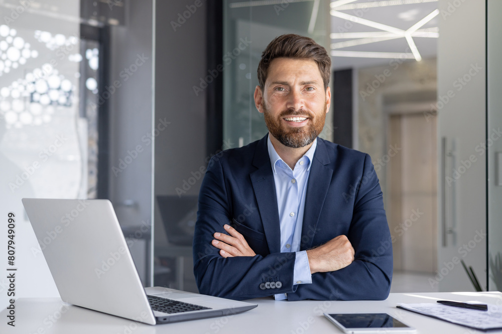 Confident businessman smiling at modern office desk Confident businessman smiling at modern office desk