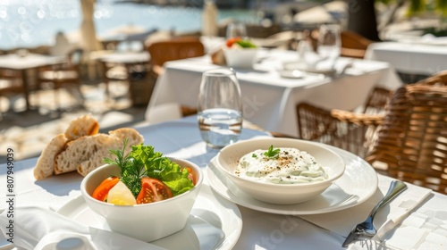 A table adorned with plates of various Greek foods and a vibrant bowl of salad