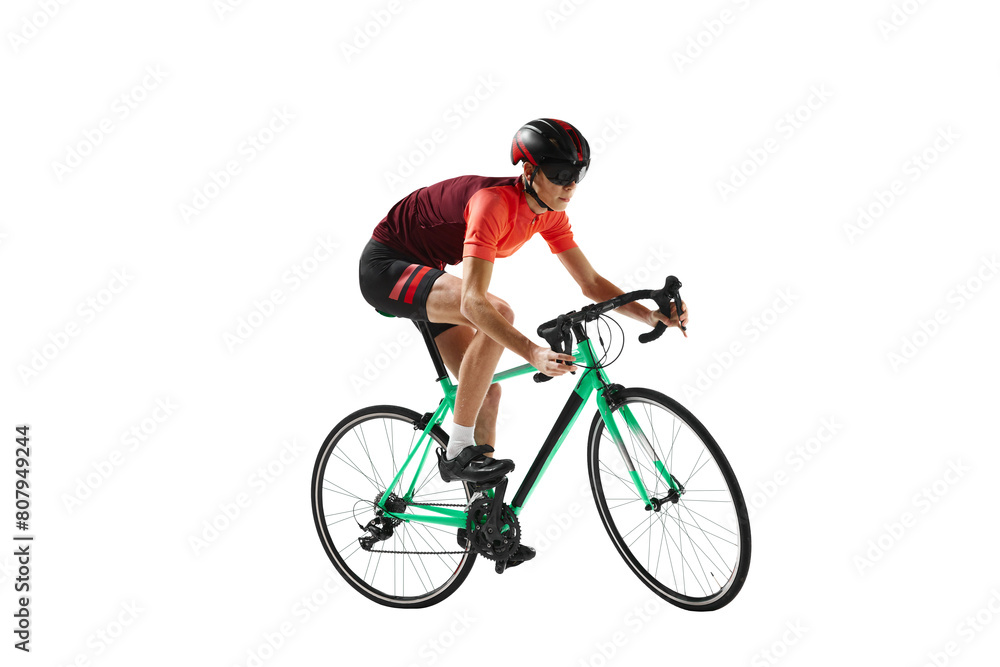Obraz premium Muscular young man, athlete, cyclist in uniform and helmet, riding bicycle against transparent background. Concept of sport, action, competition, power and endurance, healthy lifestyle.