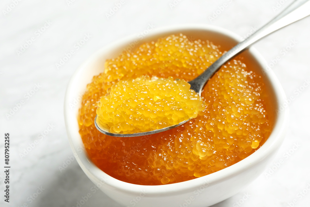 Fresh pike caviar in bowl and spoon on white table, closeup Fresh pike caviar in bowl and spoon on white table, closeup