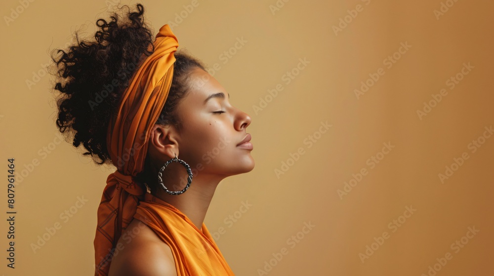 Close-up of a lovely girl with a silk scarf on her shoulders standing against cream background with copy space on the right Close-up of a lovely girl with a silk scarf on her shoulders standing against cream background with copy space on the right