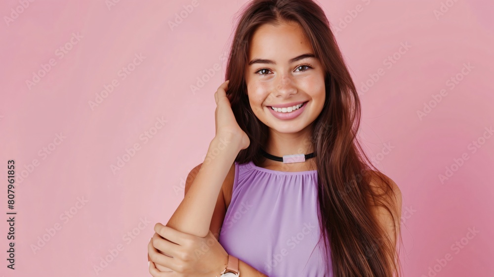 Close-up view of a beautiful brunette girl long hair wearing a lovely violet dress and stylish smartwatch, smiling and standing against pink background with copy space on the left Close-up view of a beautiful brunette girl long hair wearing a lovely violet dress and stylish smartwatch, smiling and standing against pink background with copy space on the left