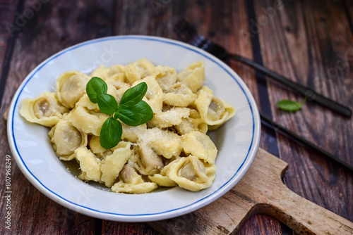 Home made vegetarian  italian   Tortellini with pesto genovese filled with   spinach   and parmesan cheese, decorated with fresh basil