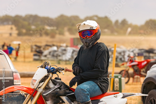 Teen boy riding motorbike at motocross track meet photo
