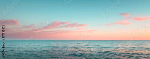 A serene ocean scene captured at sunset  where the sky and water meet in a harmonious blend of pastel pinks and blues  evoking a tranquil and picturesque setting.