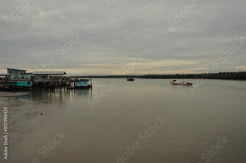 passenger ferry docked at pier people disembarking calm water hazy sky © Jacques