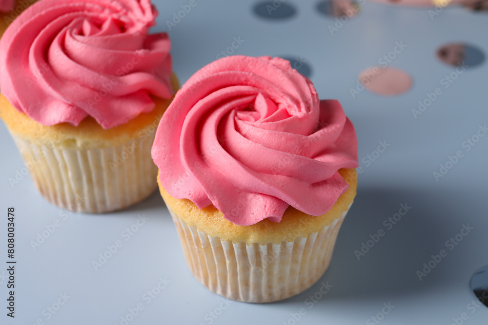 Delicious cupcakes with bright cream on light background, closeup