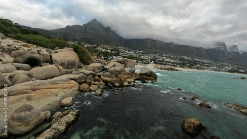 FPV Drone shot of the Camps Bay and Magnificent rocky 12 Apostles in Cape Town, South Africa at sunset