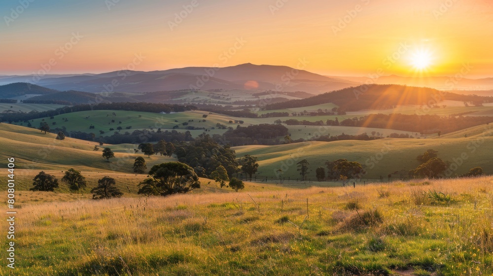 A panoramic view of the sun rising over rolling hills, rural tranquility at dawn