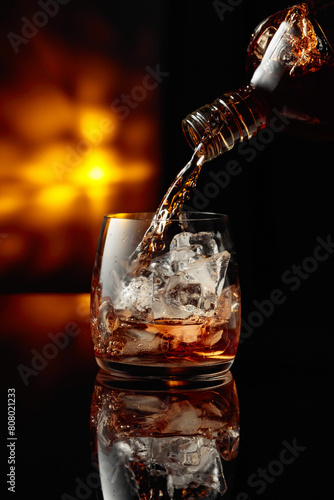 Pouring whiskey into a glass with ice.