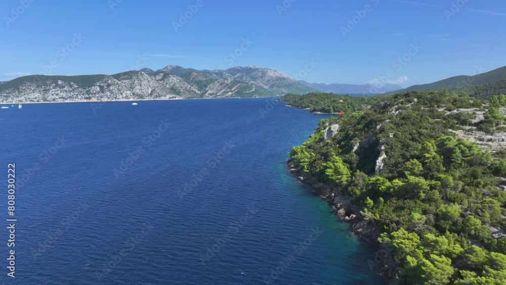 AERIAL: Flying alongside a rugged rocky seafront of the Adriatic island of Korcula. The vast blue sea stretches over the horizon and between the wild archipelago. Shot of the remote part of Korcula. AERIAL: Flying alongside a rugged rocky seafront of the Adriatic island of Korcula. The vast blue sea stretches over the horizon and between the wild archipelago. Shot of the remote part of Korcula.