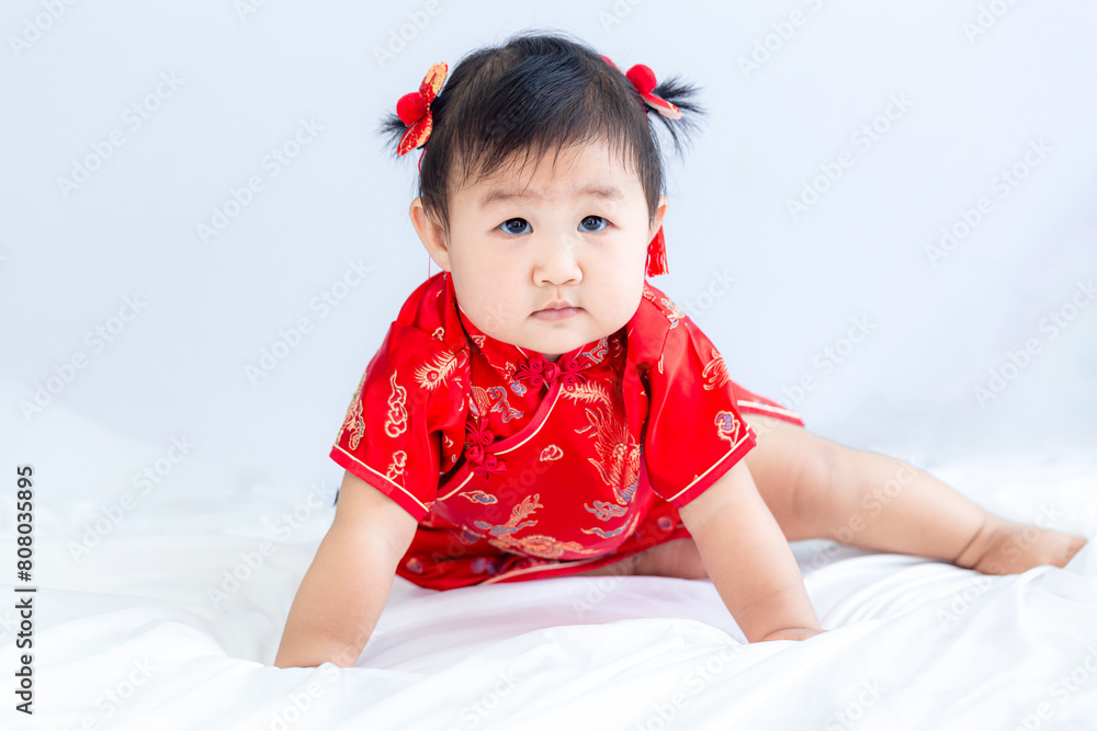 Chinese New Year concept, cute happy little girl in Chinese dress sitting in white living room. Cute Asian baby sitting in white living room, Chinese New Year concept. Chinese New Year concept, cute happy little girl in Chinese dress sitting in white living room. Cute Asian baby sitting in white living room, Chinese New Year concept.
