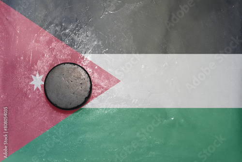 old hockey puck is on the ice with national flag of jordan . photo