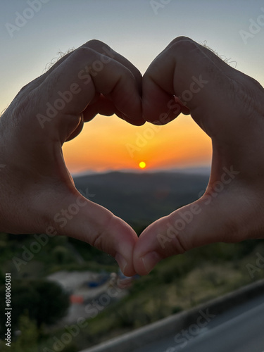 zachodzące słońce nad gó®mai wewnątrz serca z dłoni - walentynkowy widok © Kamil_k2p