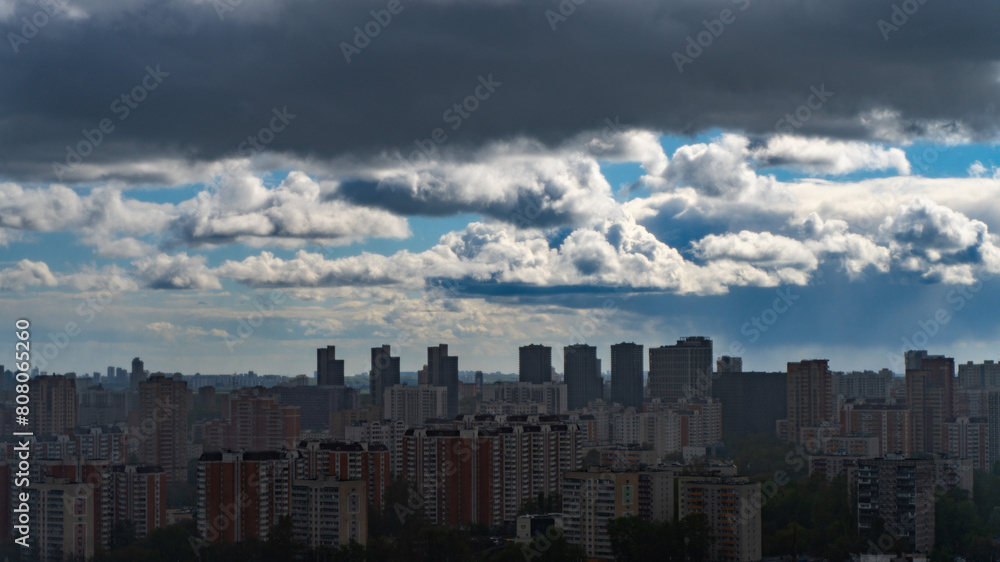 Panoramic view of Moscow's multi-storey buildings covered with the shadow of a storm cloud against the background of blue sky and white clouds. Khovrino District. Selected Focus. High quality photo