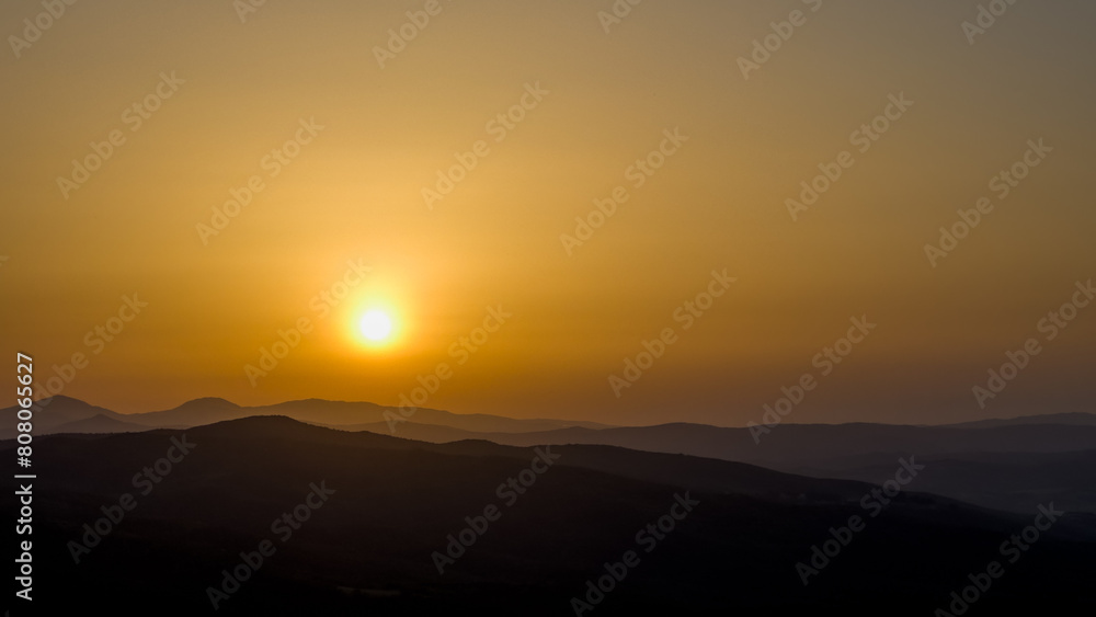 Obraz premium zachodzące słońce nad szczytami gór otaczającymi dolinę val darcia w Toskanii