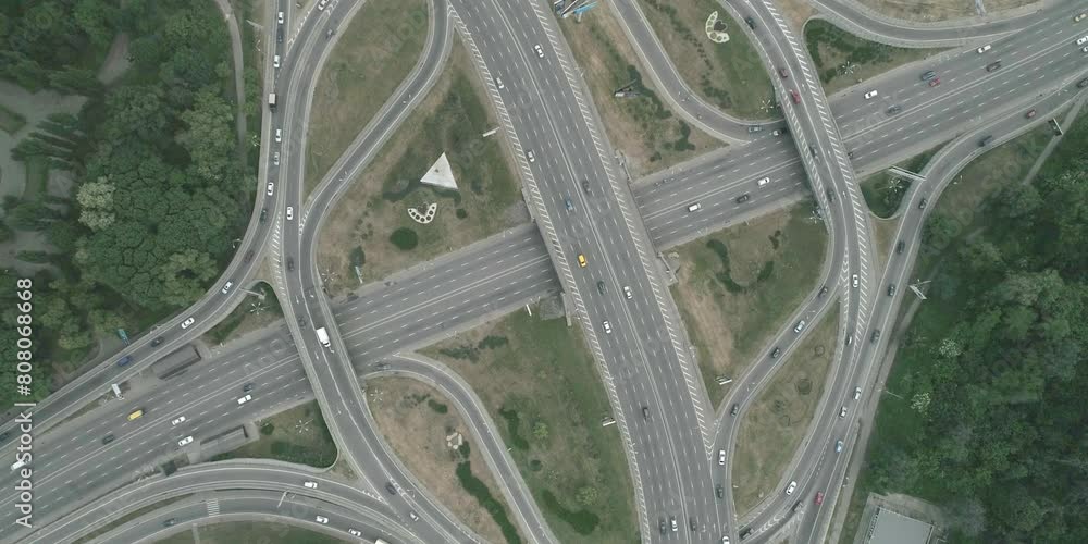 Large transport interchange on highway. Top view of traffic on roundabout, Intense traffic on highway on big junction with bridges and tunnels Large transport interchange on highway. Top view of traffic on roundabout, Intense traffic on highway on big junction with bridges and tunnels