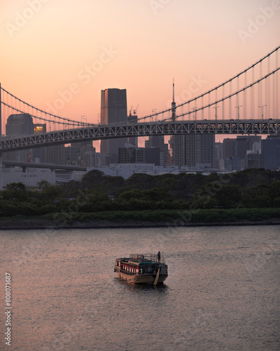 Tableau sur toile Bridge over Tokyo bay on sunset and with a boat on the river
