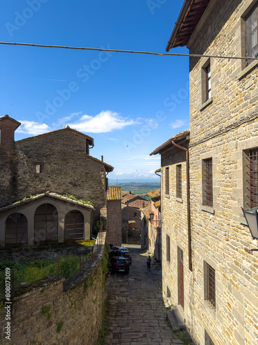 urokliwa uliczka miedzy kamiennymi kamienicami, Cortona, Włochy photo