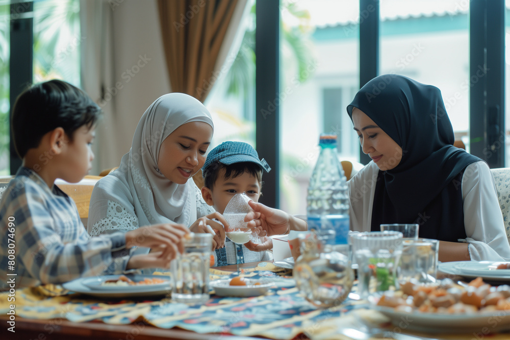 Smiling Family in Traditional Islamic Clothing Enjoying A Festive Meal Indoors Smiling Family in Traditional Islamic Clothing Enjoying A Festive Meal Indoors