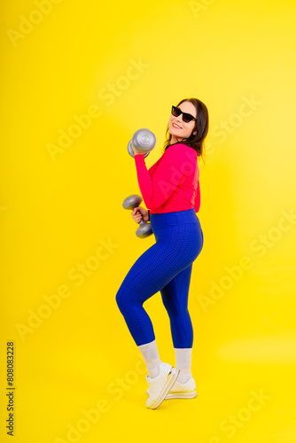 Sporty plump woman doing exercises with dumbbells. Sports motivation and healthy lifestyle