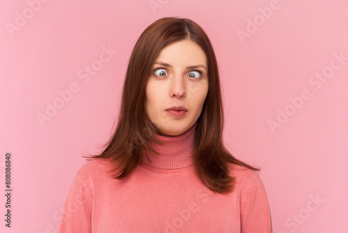 Schilderij op canvas Attractive funny silly woman with brown hair with cross eyed, has stupid dumb face, awkward confused comical expression, wearing rose turtleneck