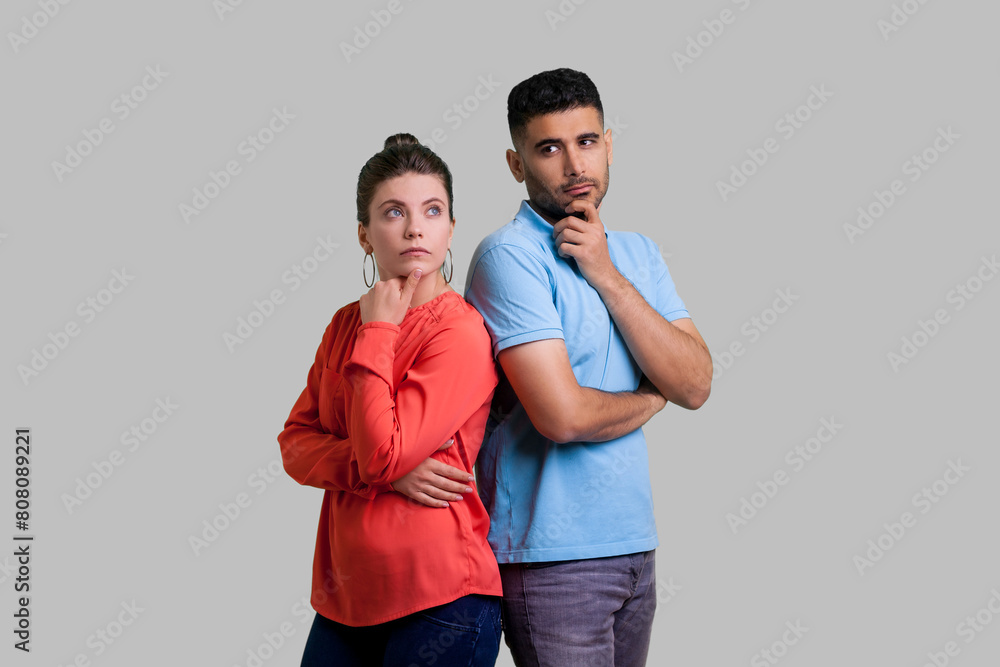 Φωτογραφία Portrait of pensive thoughtful couple man and woman standing together holding chins thinking about something important