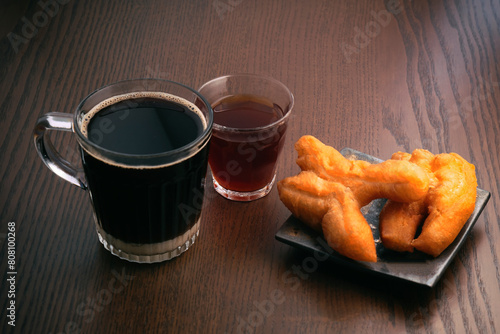 Hot black coffee and hot Chinese tea Eat with fried dough snacks.