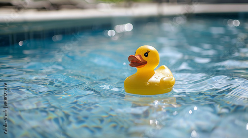 A yellow rubber ducky floats happily in a swimming pool, a classic summer toy. It represents the joy, freedom, and playful spirit of childhood.