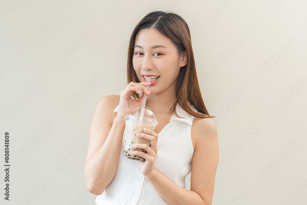Beverage and food concept, Happy asian young woman hand holding plastic cup, glass of drink bubble, pearl milk tea with straw, cute girl drinking ice cold tea with tapioca boba ball popular in Taiwan. Beverage and food concept, Happy asian young woman hand holding plastic cup, glass of drink bubble, pearl milk tea with straw, cute girl drinking ice cold tea with tapioca boba ball popular in Taiwan.