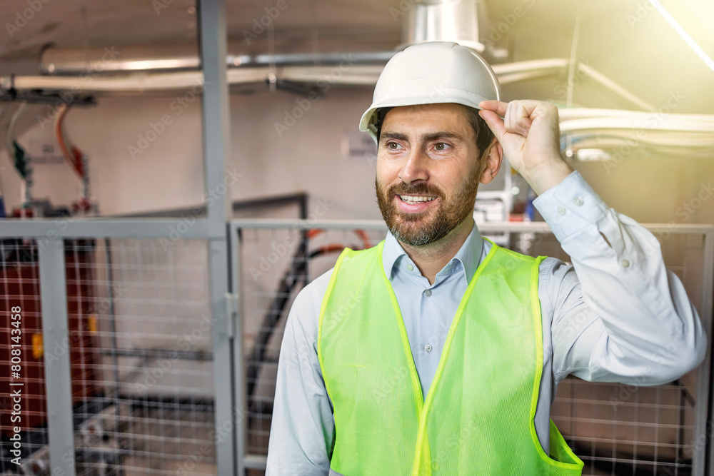 Smiling and happy employee. Industrial worker indoors in factory. Young technician with hard hat. Smiling and happy employee. Industrial worker indoors in factory. Young technician with hard hat.