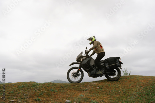 Motorcyclist traveling on adventure tourist enduro motorcycle outdoor in mountains