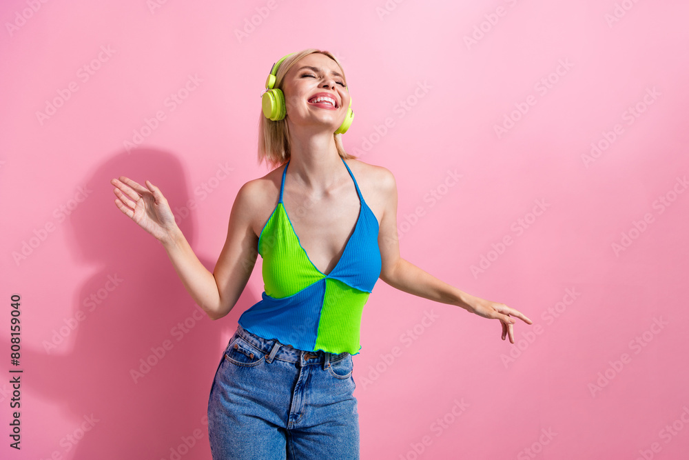 Photo of dreamy funky girl with bob hairdo dressed colorful tank in headphones enjoy pop playlist isolated on pink color background Photo of dreamy funky girl with bob hairdo dressed colorful tank in headphones enjoy pop playlist isolated on pink color background