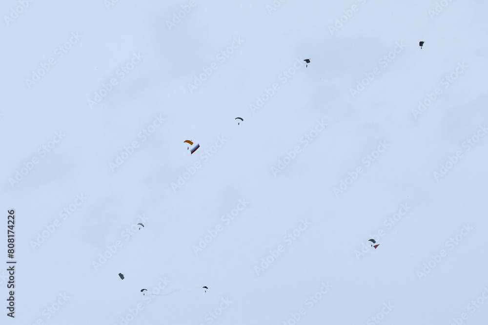 Airborne forces paratroopers soaring holding Flag of Russia and flags of military units, military exercise for celebration of Airborne Forces Day with formation landing, army airborne division descend Airborne forces paratroopers soaring holding Flag of Russia and flags of military units, military exercise for celebration of Airborne Forces Day with formation landing, army airborne division descend