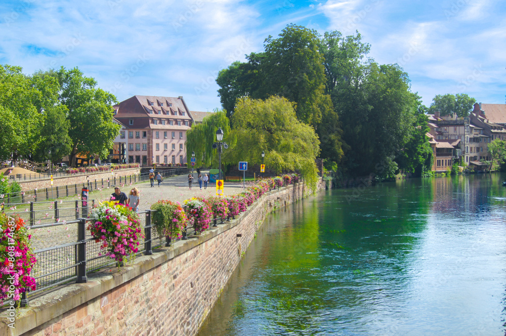 Fototapeta premium city of peace in summer combination of flowers and river, and sidewalk along the river
